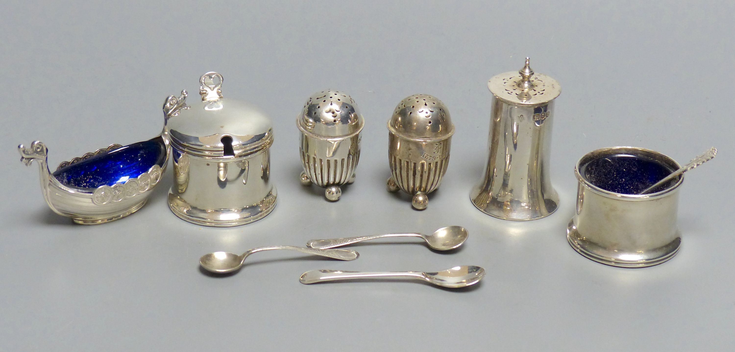 A collection of silver condiments, including a Norwegian 'Viking' longboat salt,